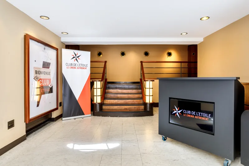 Le hall d'accueil, son écran et les marches vers la salle