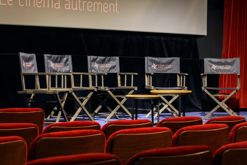 Des chaises de réalisateur alignées sur le plateau, devant l'écran