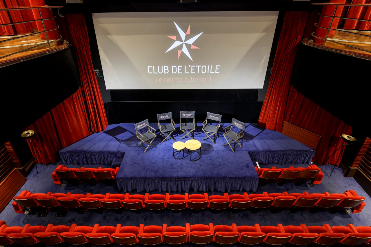 La salle en configuration conférence : plateau, fauteuils et écran