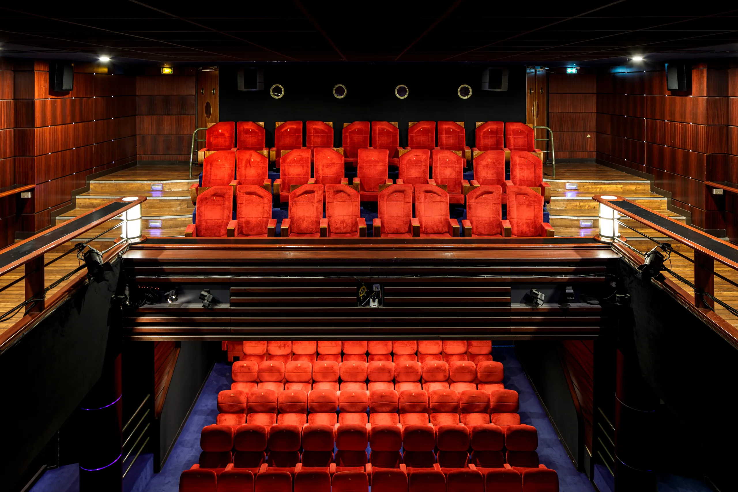 The auditorium seen from the stage: tiers of red seats and the balcony
