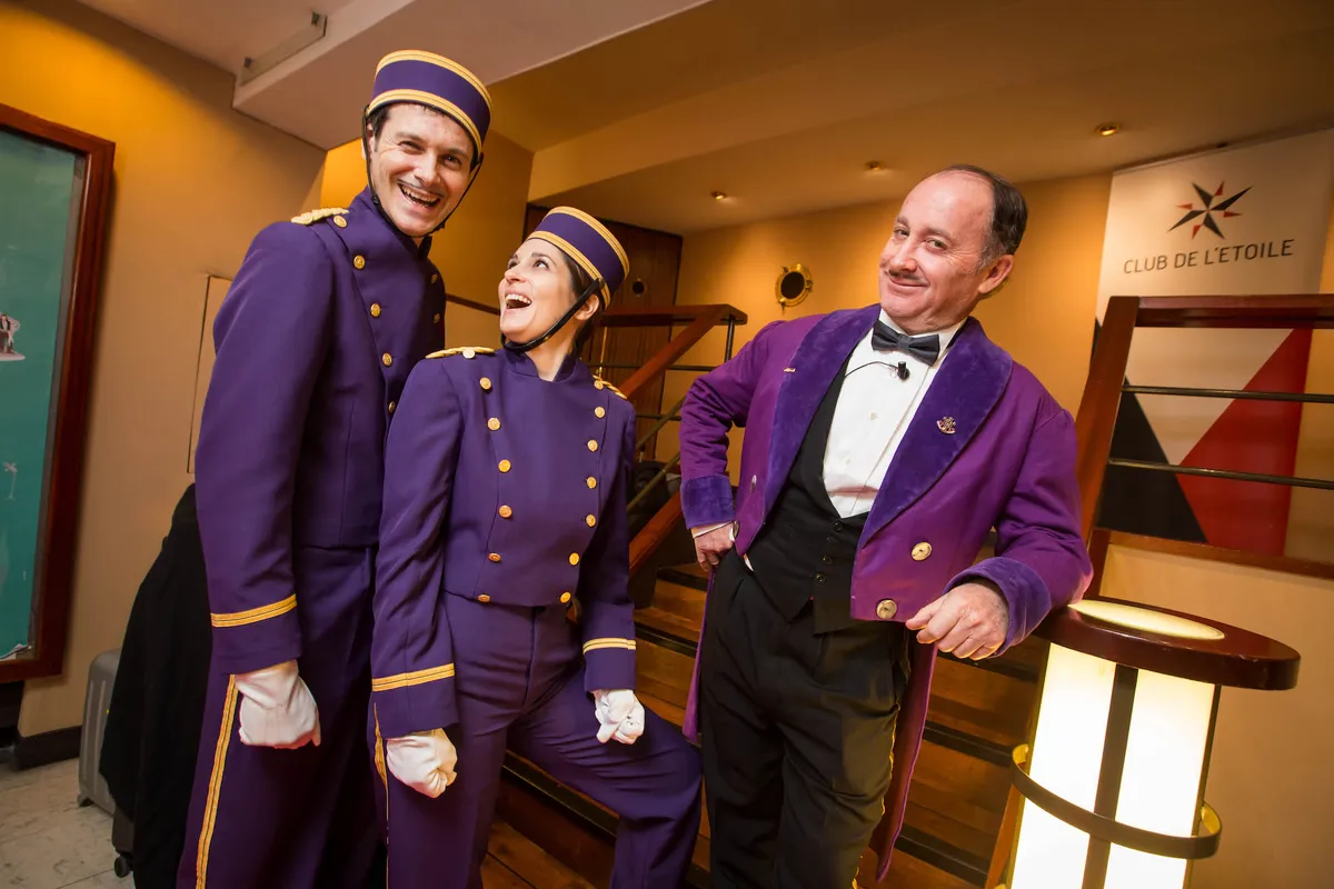 Performers in bellhop costume welcoming guests